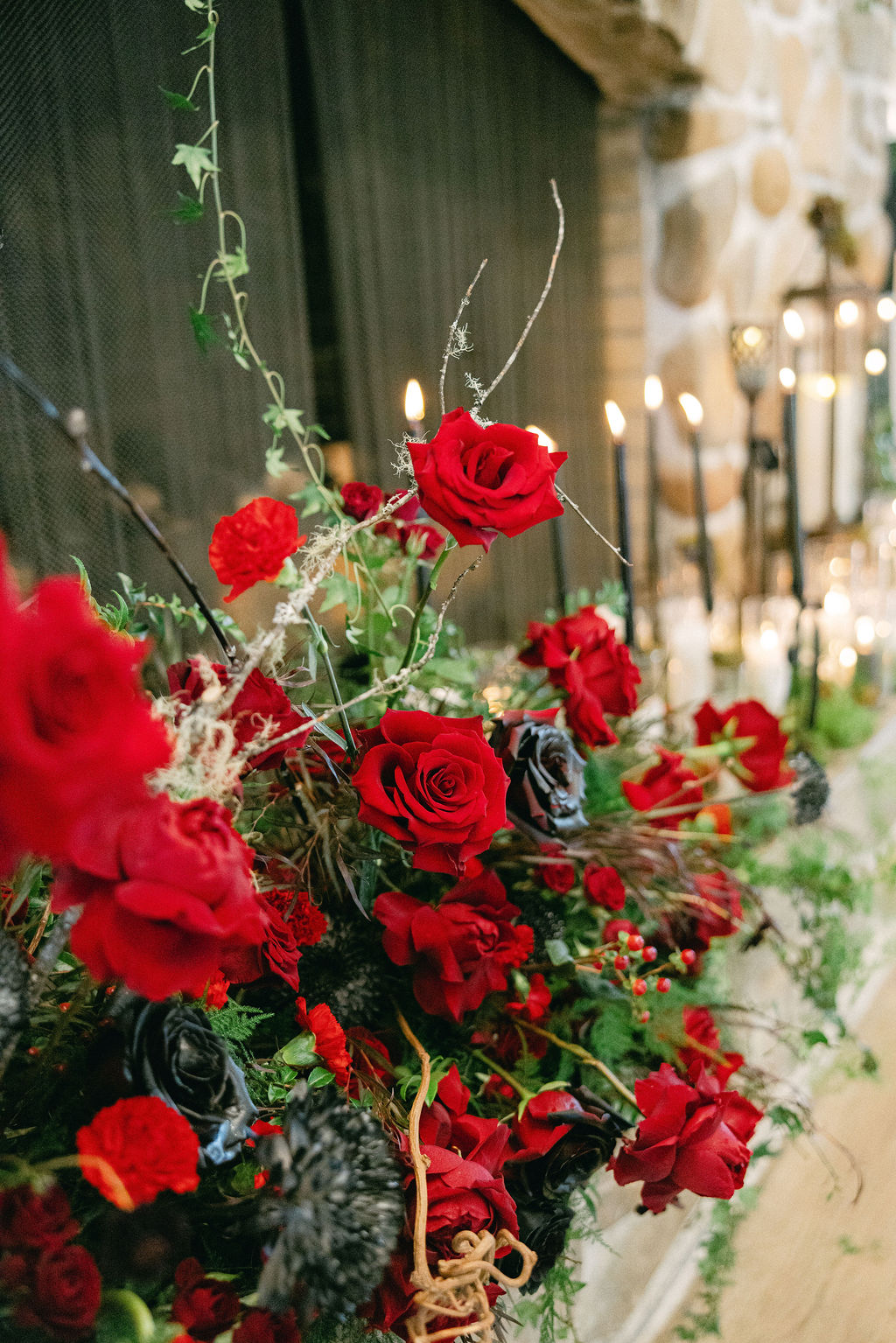 Deep red roses in a candlelit arrangement