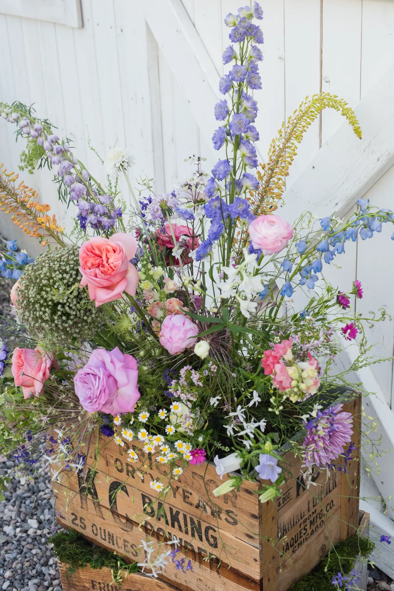 Tall installation of delphinium and pink roses