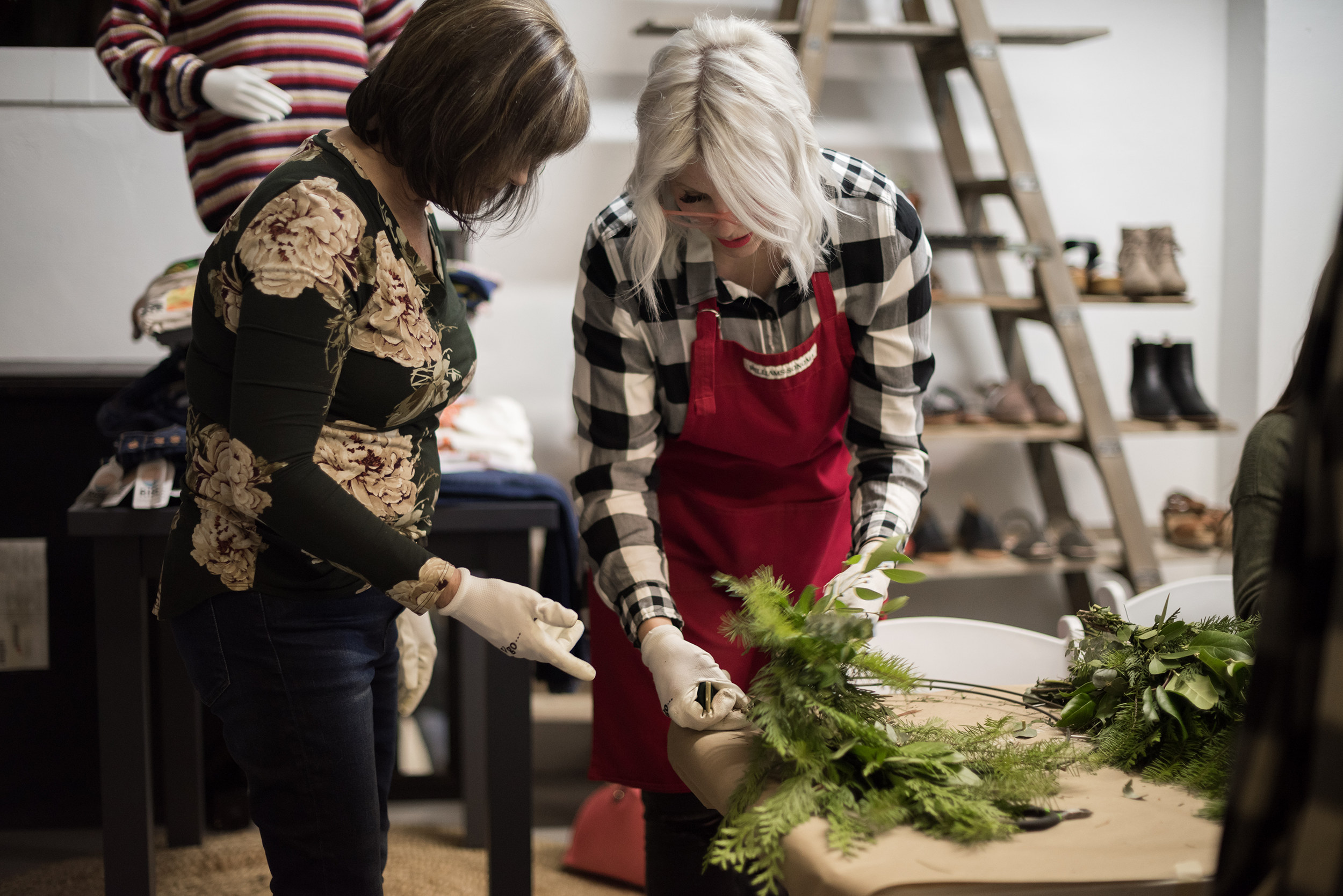 Guests building evergreen wreaths together at a hands-on Flamingo Friday wreath workshop