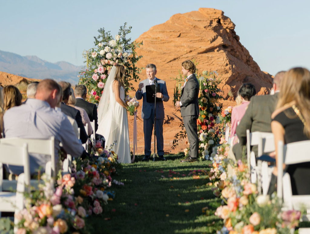 Ceremony aisle lined with florals in front of red rock