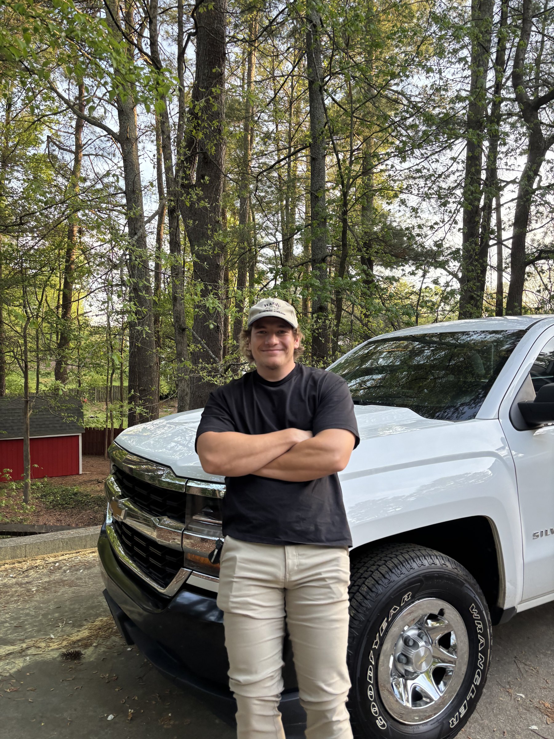 Tomahawk Junk Removal owner standing in front of his white Chevy Silverado pickup truck in Marietta, GA