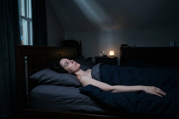 Person lying awake in a dimly lit room