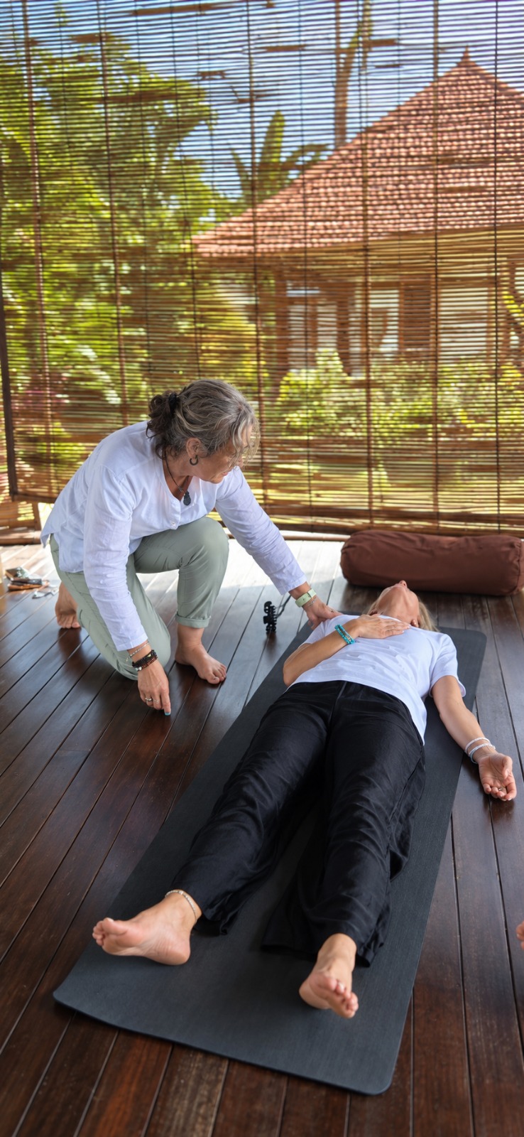 Lily Alan supporting a client lying on a mat during a HypnoBreathWork session
