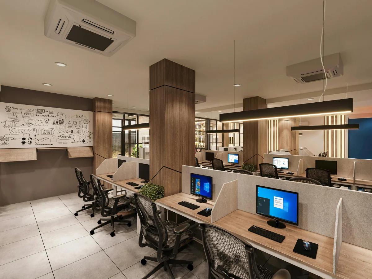 A modern open-plan office with rows of wooden desks, computers, ergonomic chairs, and a whiteboard with diagrams.