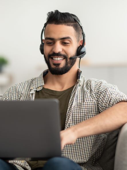 smiling man of colour with laptop and headset