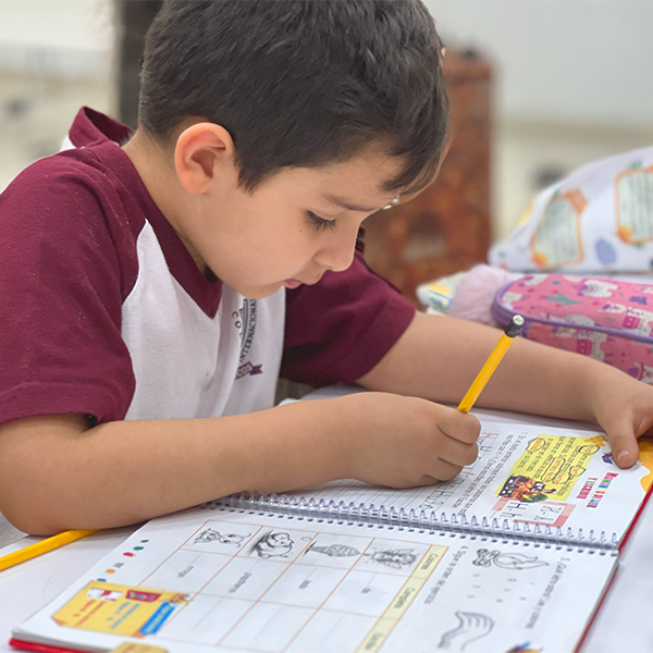 Estudiante de primaria trabajando en su cuaderno en clase