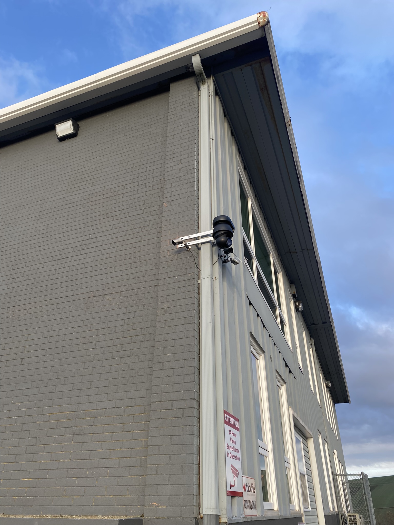 Tabufile Atlantic building exterior with security camera installation and 24-hour surveillance signage