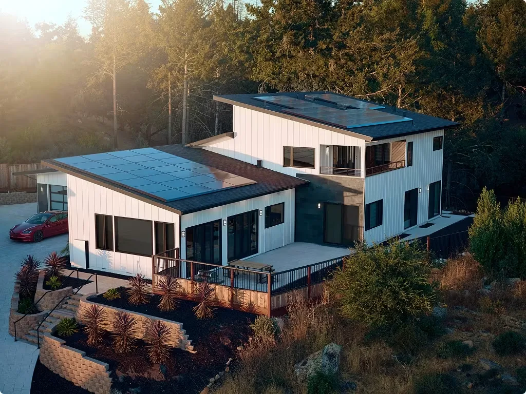 Home with all-black solar panels among trees