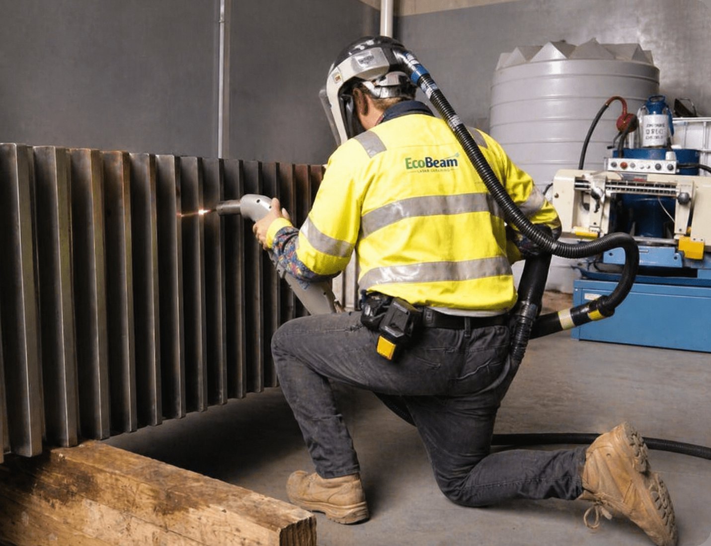 EcoBeam technician kneeling while laser cleaning industrial machinery on-site in Monaghan, Ireland