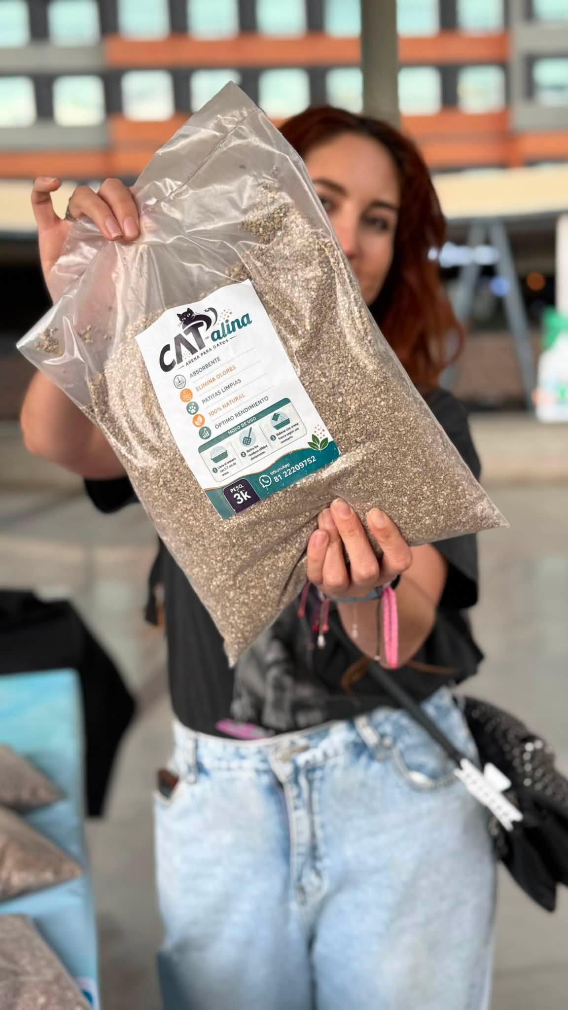 Voluntaria de la Fundación mostrando una bolsa de CAT-alina en una campaña
