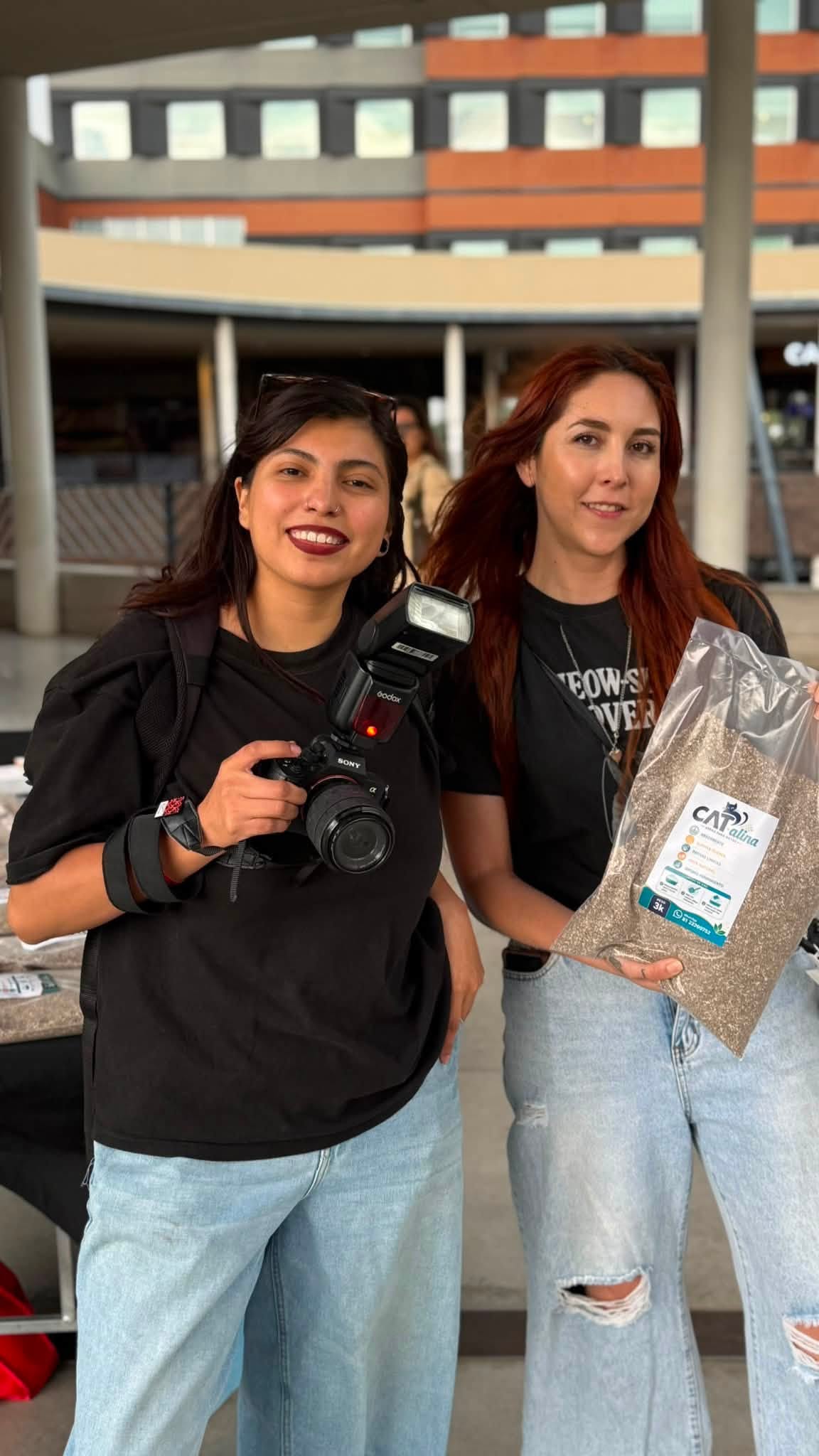 Dos voluntarias sosteniendo una bolsa de arena CAT-alina en una jornada