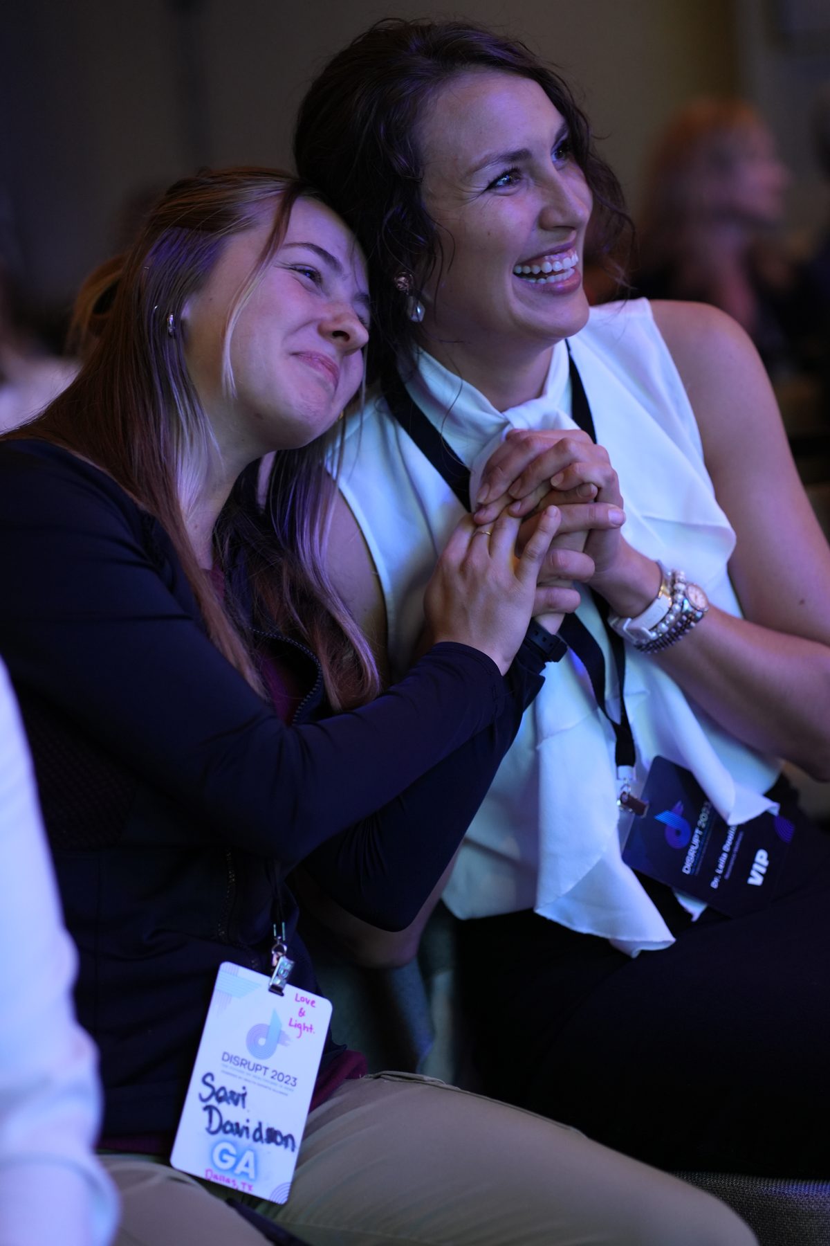 Two members hugging and laughing at Disrupt