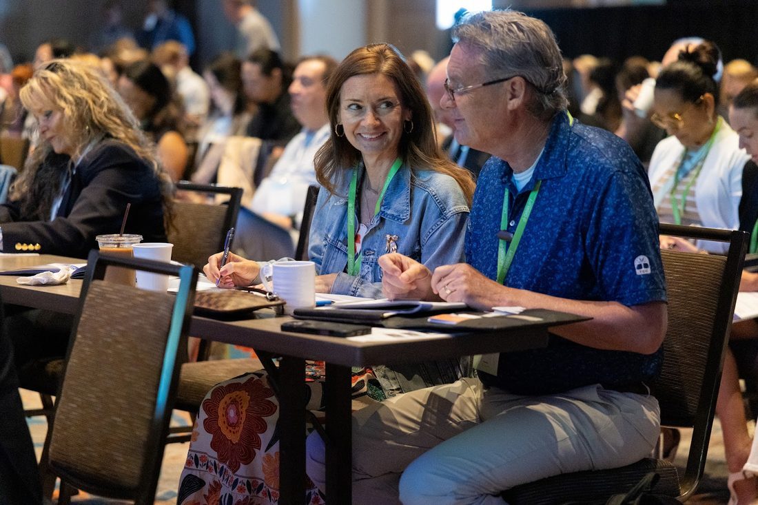 Two members smiling at a session table