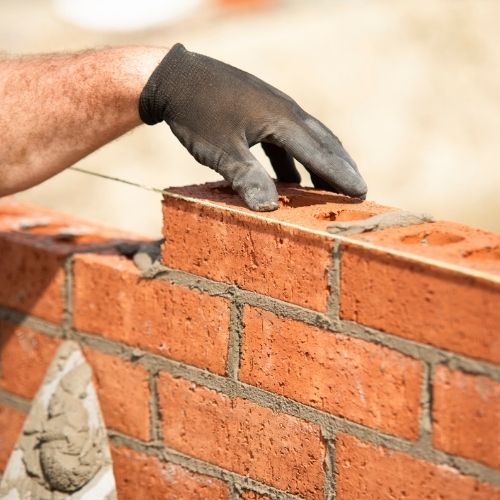 Masonry contractor in Fresno, TX repairing damaged brick joints