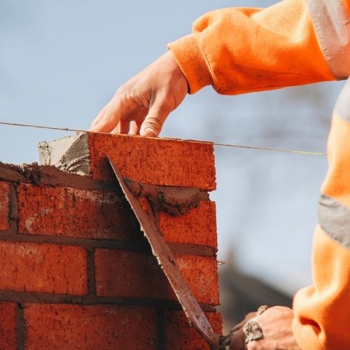 Masonry contractor in Fresno, TX installing a stone patio