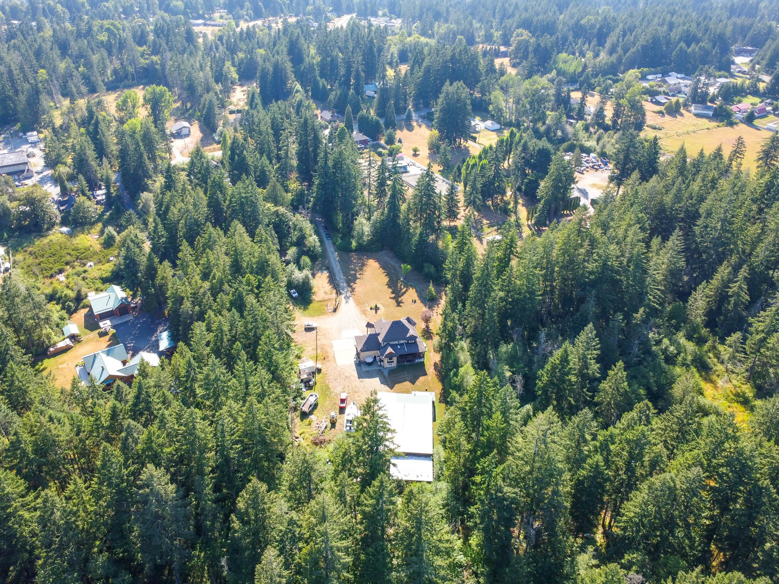 Aerial view of the home, detached shop and acreage at 6091 Beaver Creek Road in Port Alberni