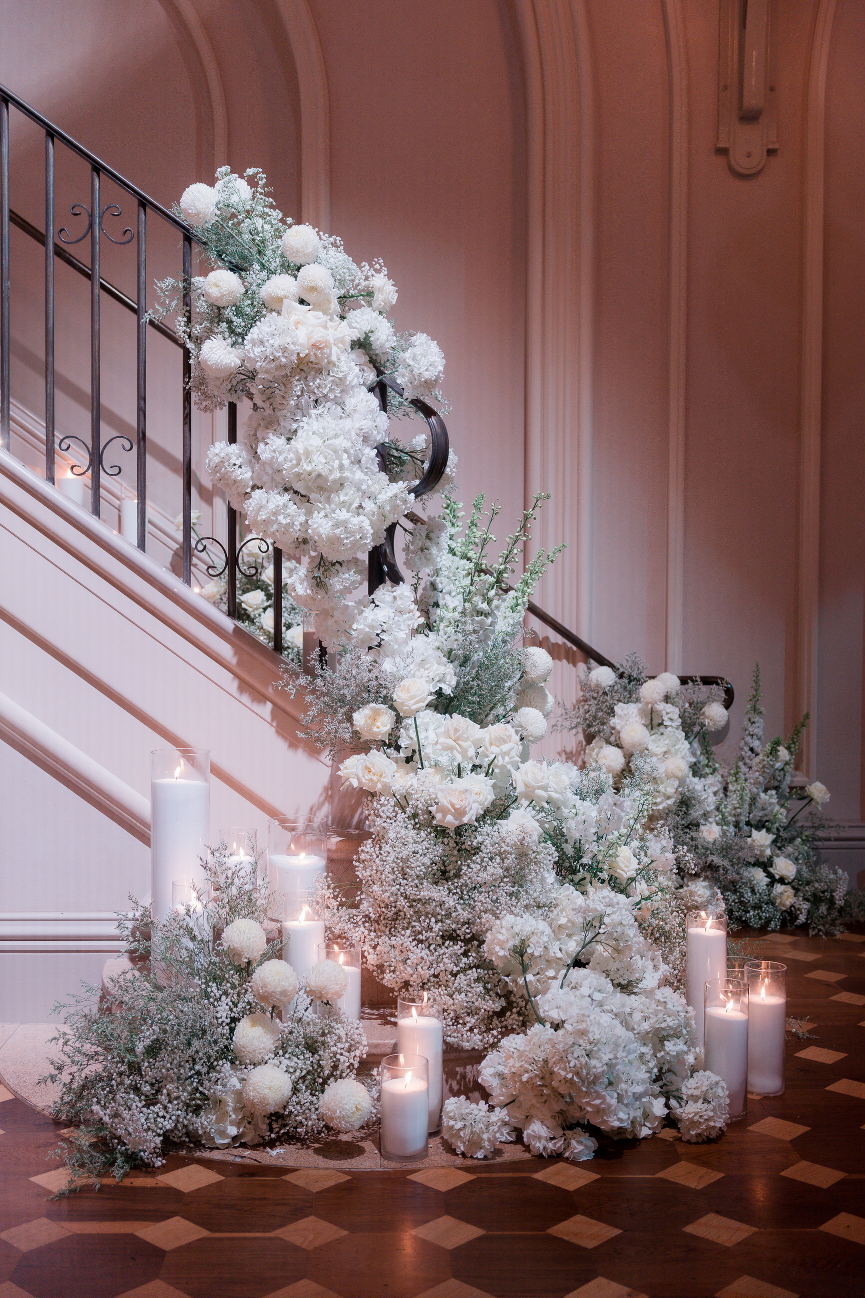 White flowers cascading down a heritage staircase with candles