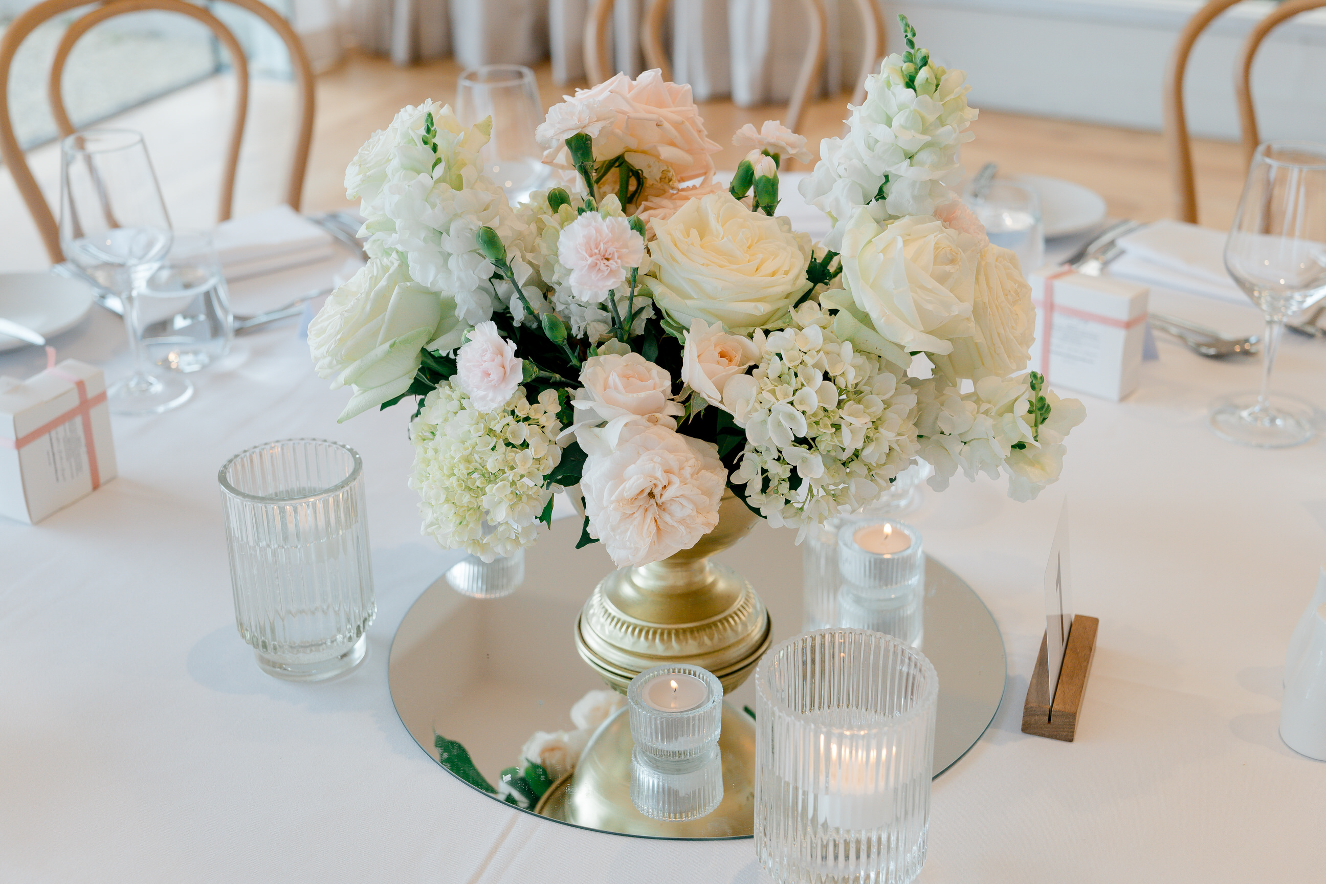 White and blush centrepiece on a mirror with candles