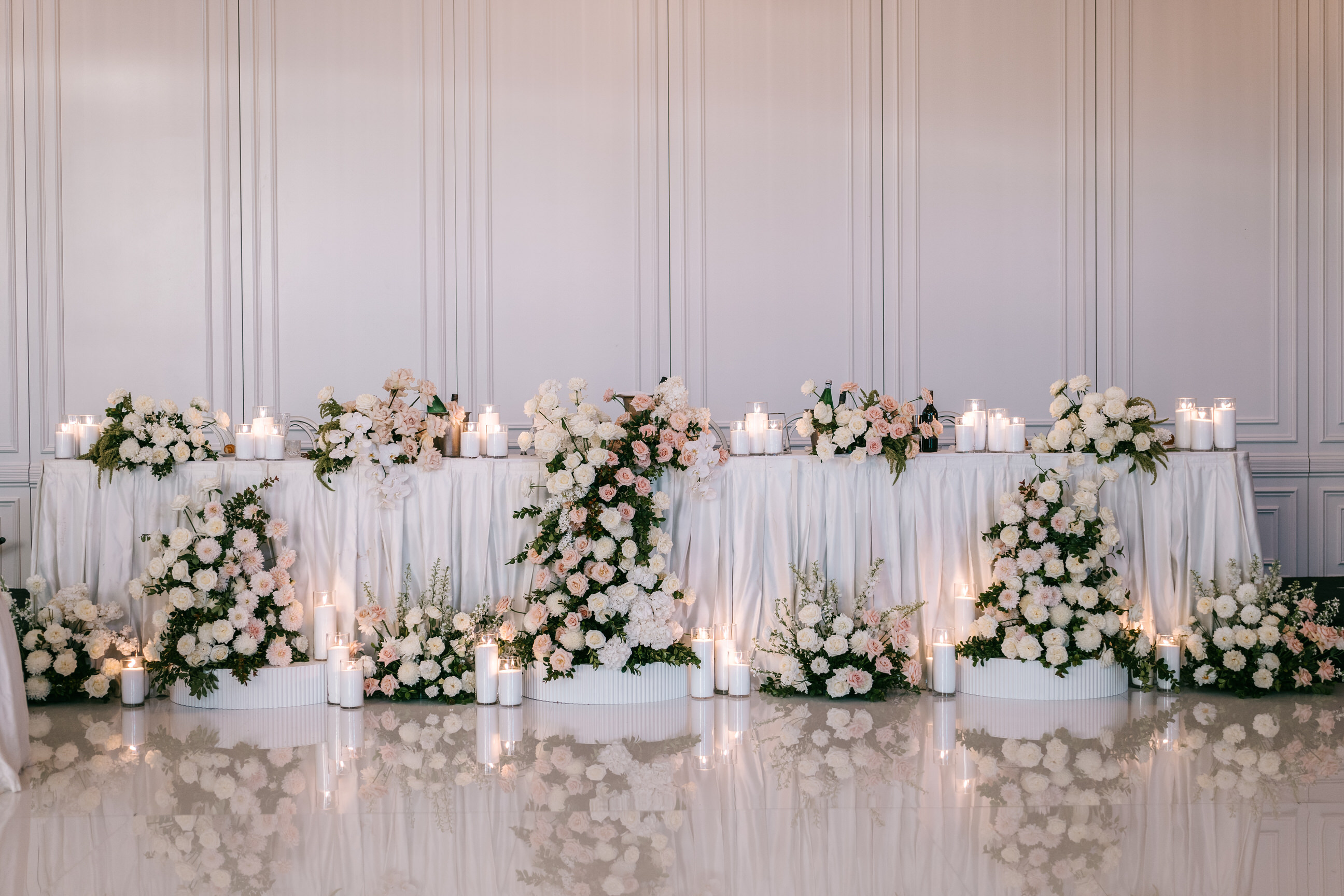 Blush bridal table with candles against a panelled wall