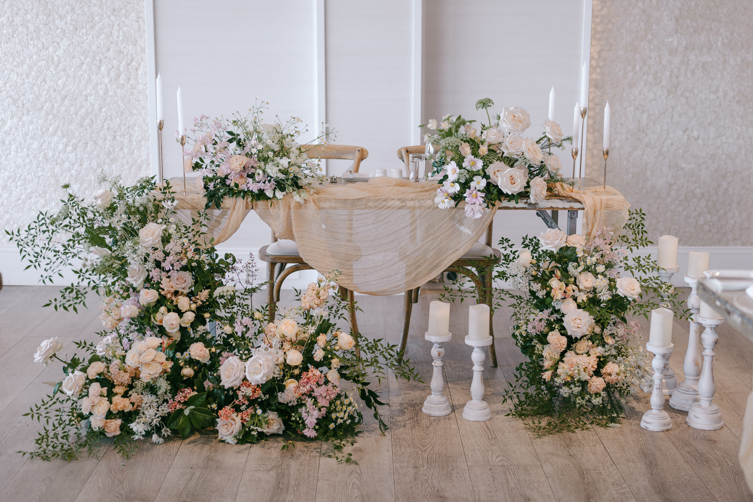 Sweetheart table styled with white and blush florals and candles