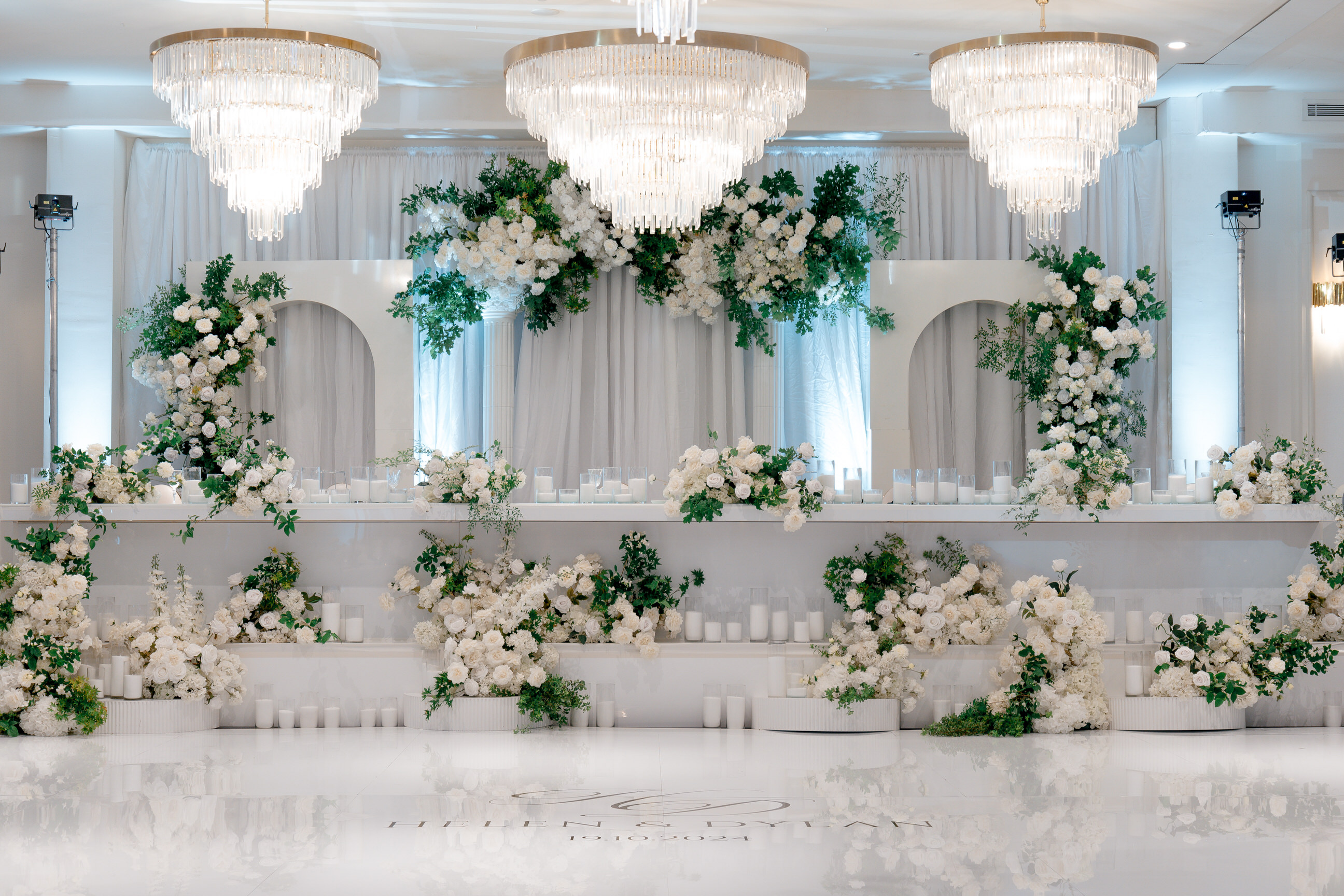 Arched backdrop with chandeliers and white florals