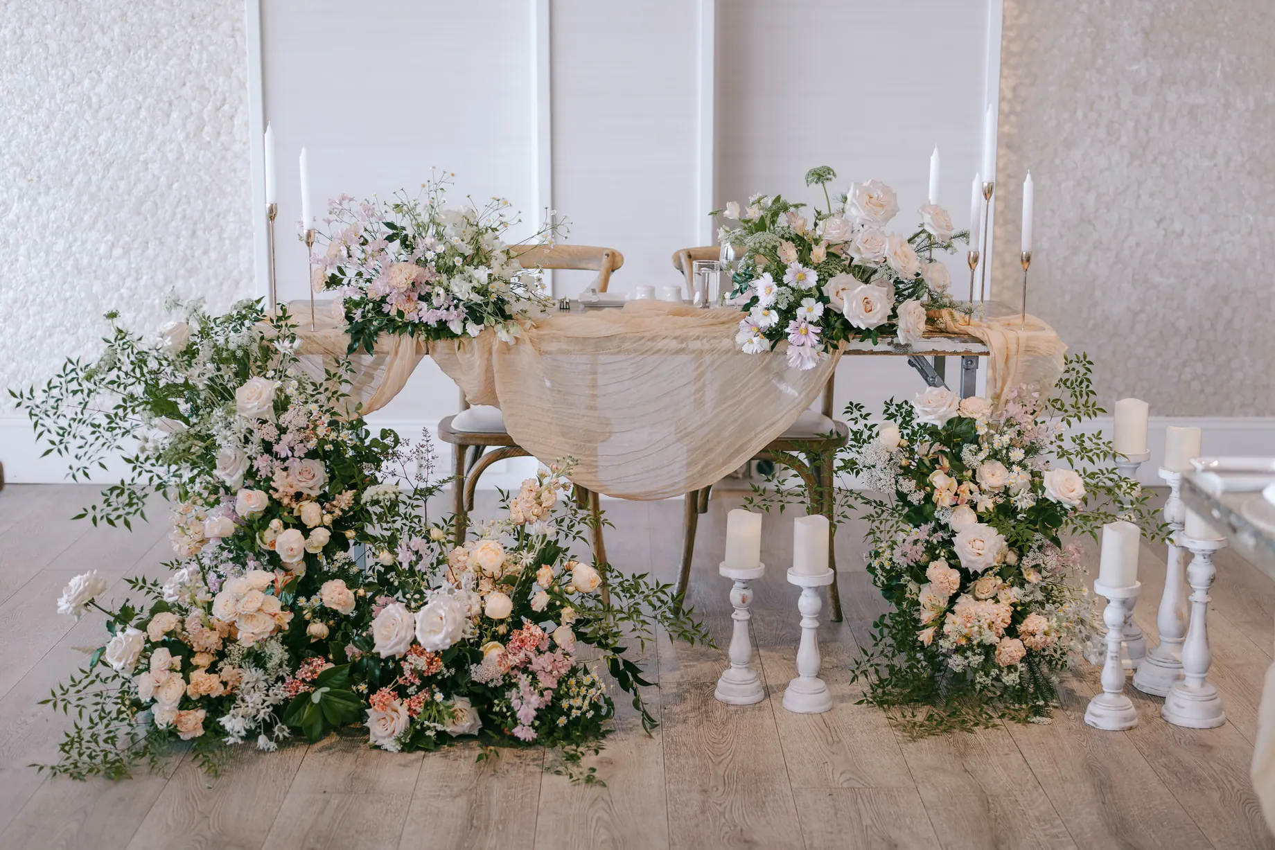 Sweetheart table styled with white and blush florals and candles