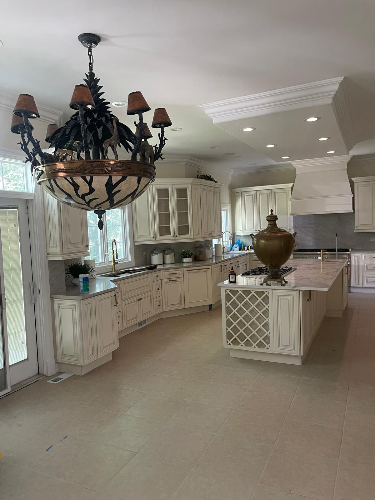 A modern kitchen with white cabinets dark countertops and stainless steel appliances after a professional remodel