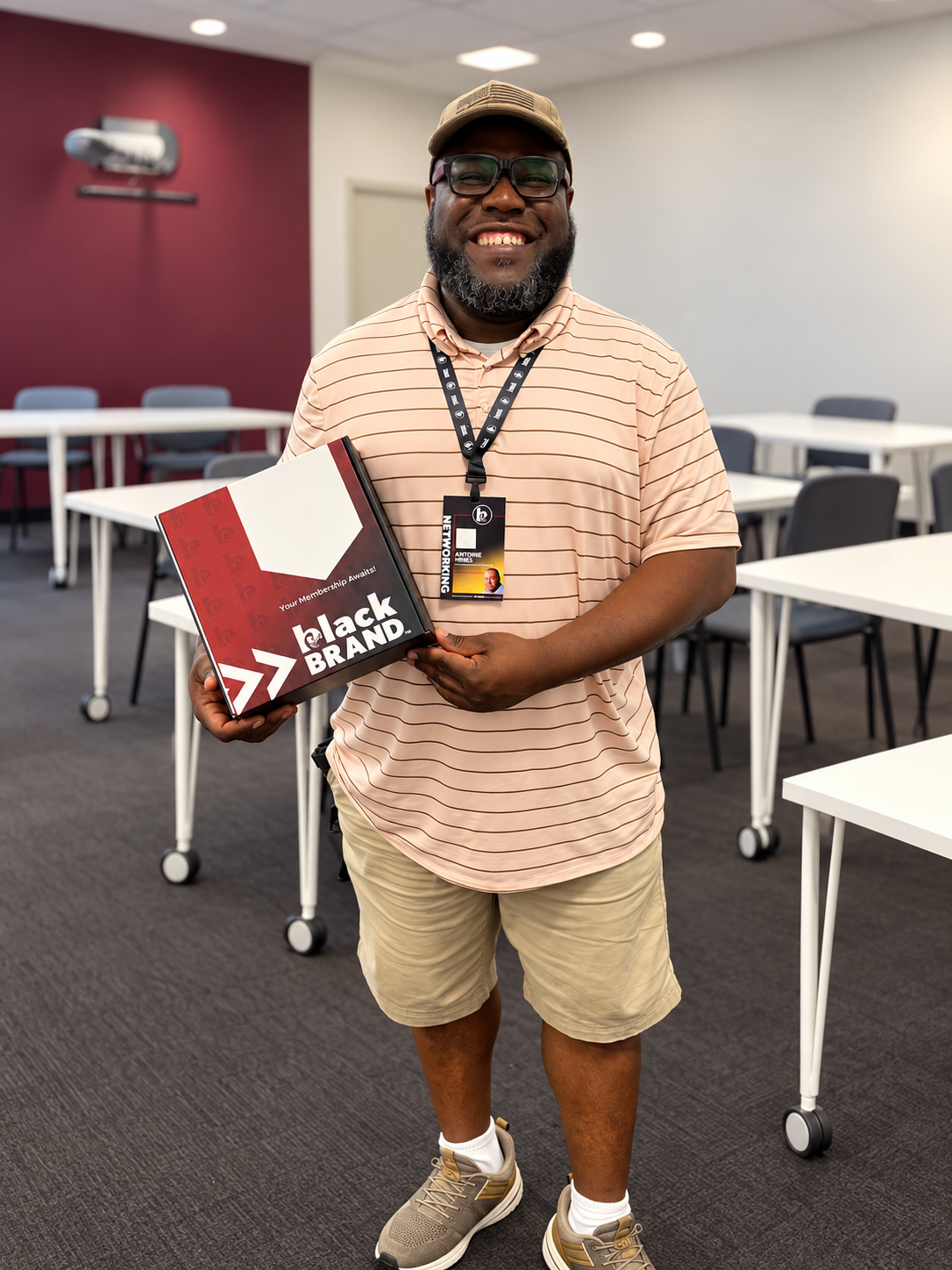 Black BRAND member holding membership kit and badge