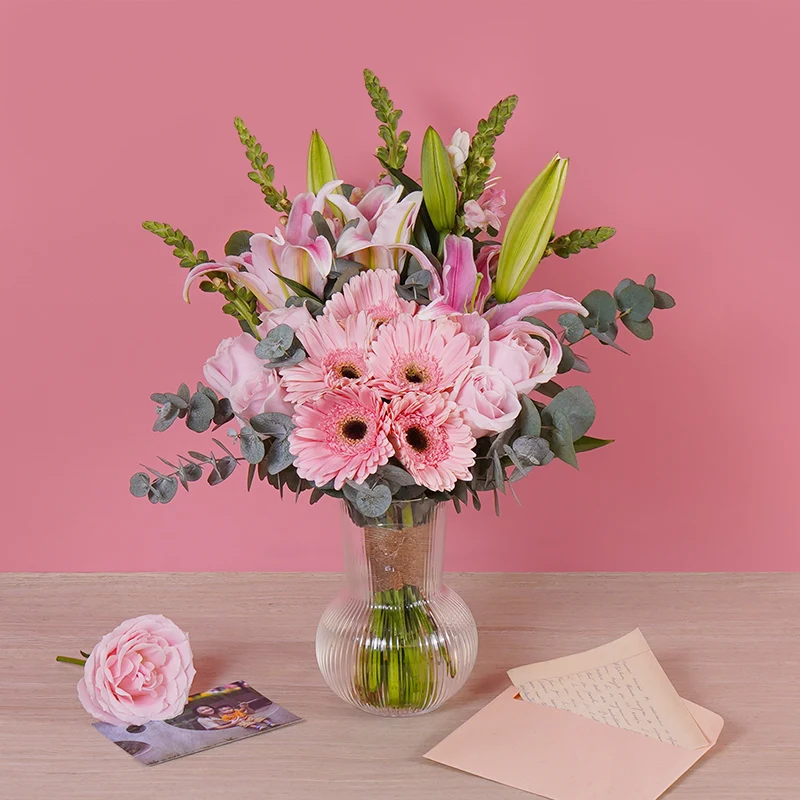 Pink lilies and gerbera daisies in a glass vase