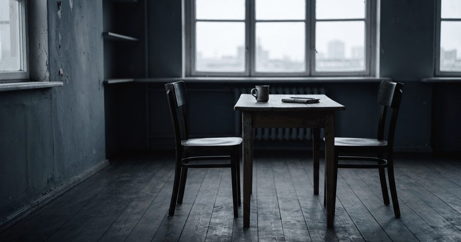 Two chairs at a small table by a window