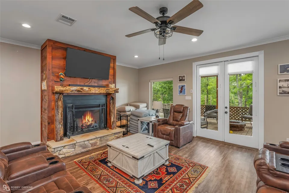 Living room with a mesquite fireplace surround and doors to the deck
