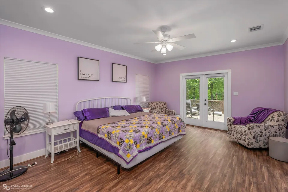 Primary bedroom with purple walls and doors to the deck