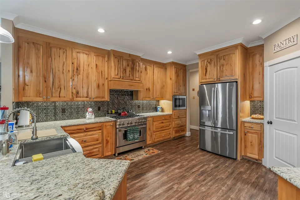 Kitchen with natural wood cabinetry, granite counters and stainless appliances