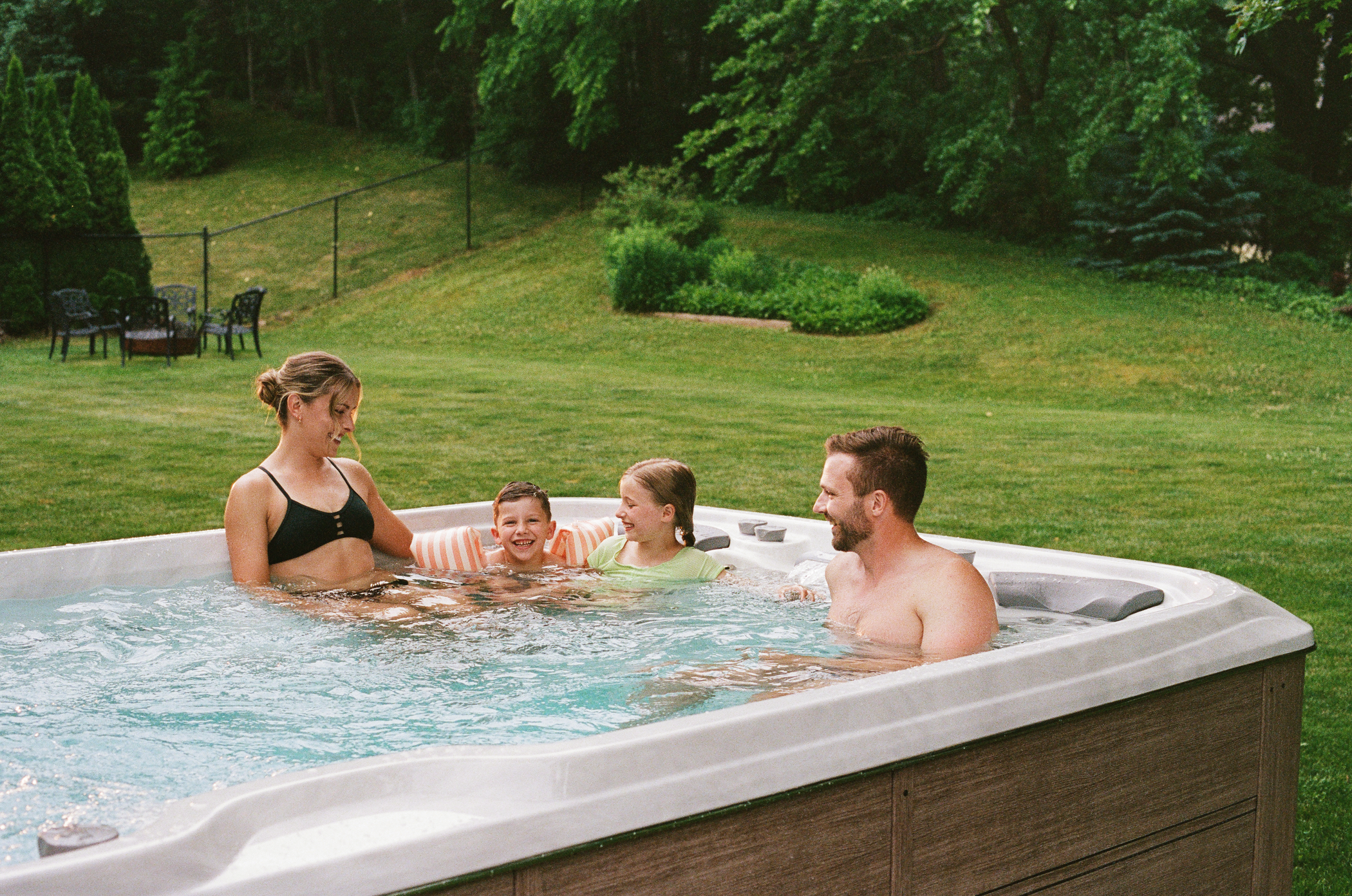 Family enjoying a swim spa together outdoors