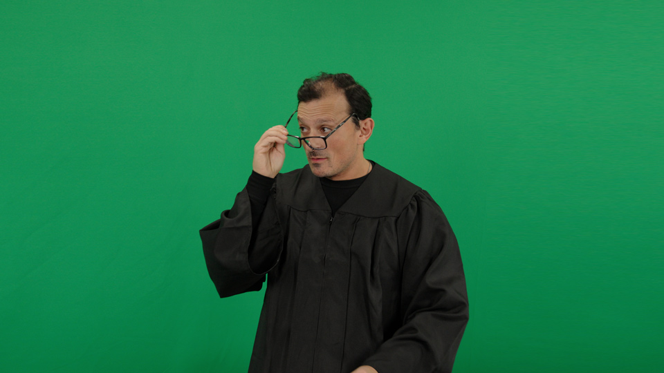 The same frame on set: the performer in judge's robes in front of the green screen