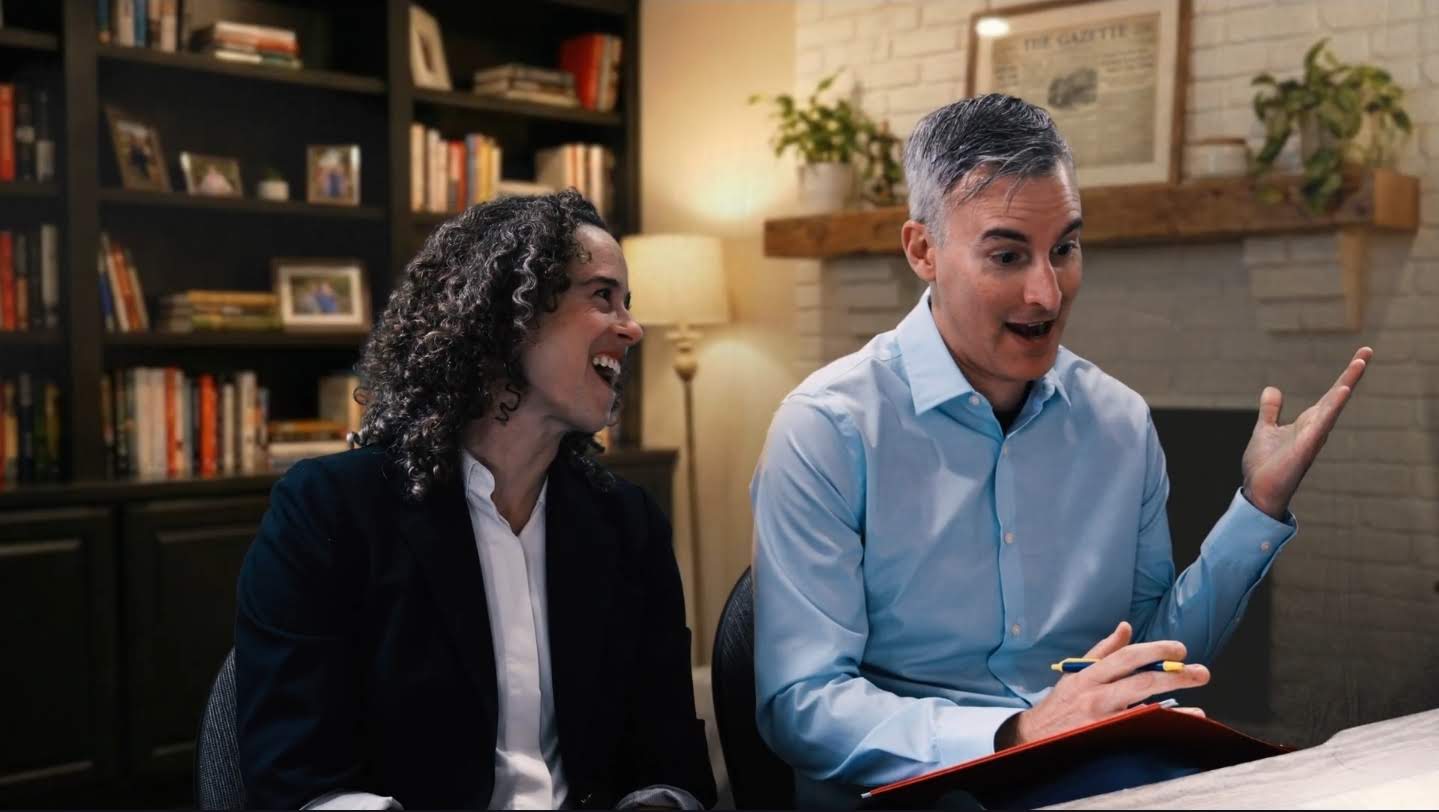 The Gazette, reporters' angle: two reporters at the table in front of a virtual study with a bookshelf and fireplace