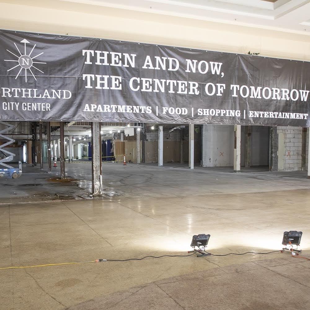 A banner reading Then and Now, the Center of Tomorrow hung inside the empty historic building