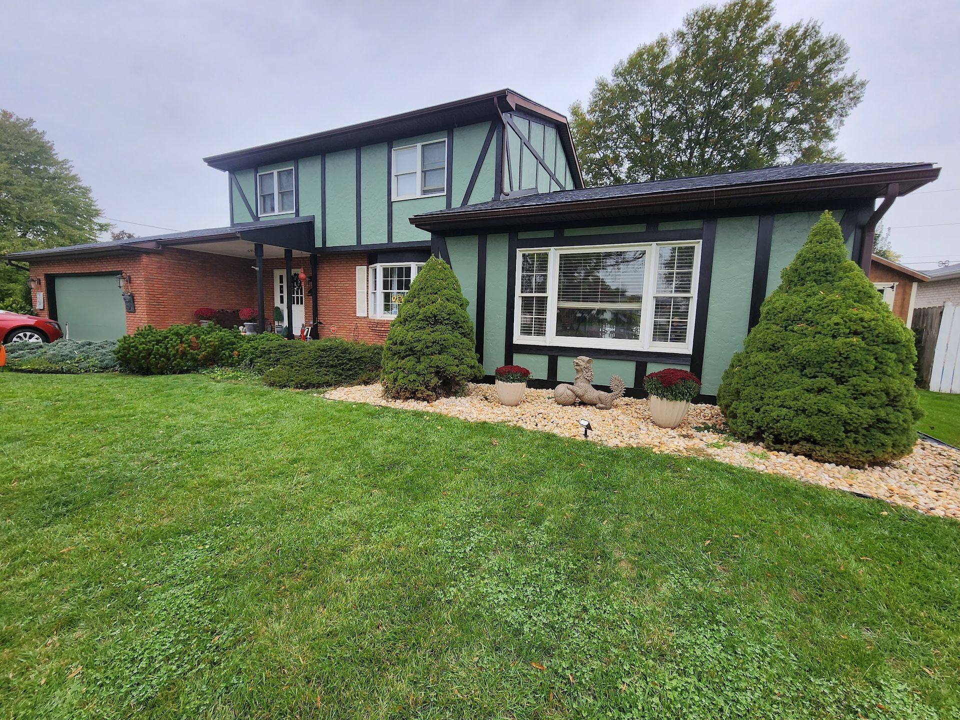 Exterior repaint with green field color, black trim accents, and restored facade contrast.