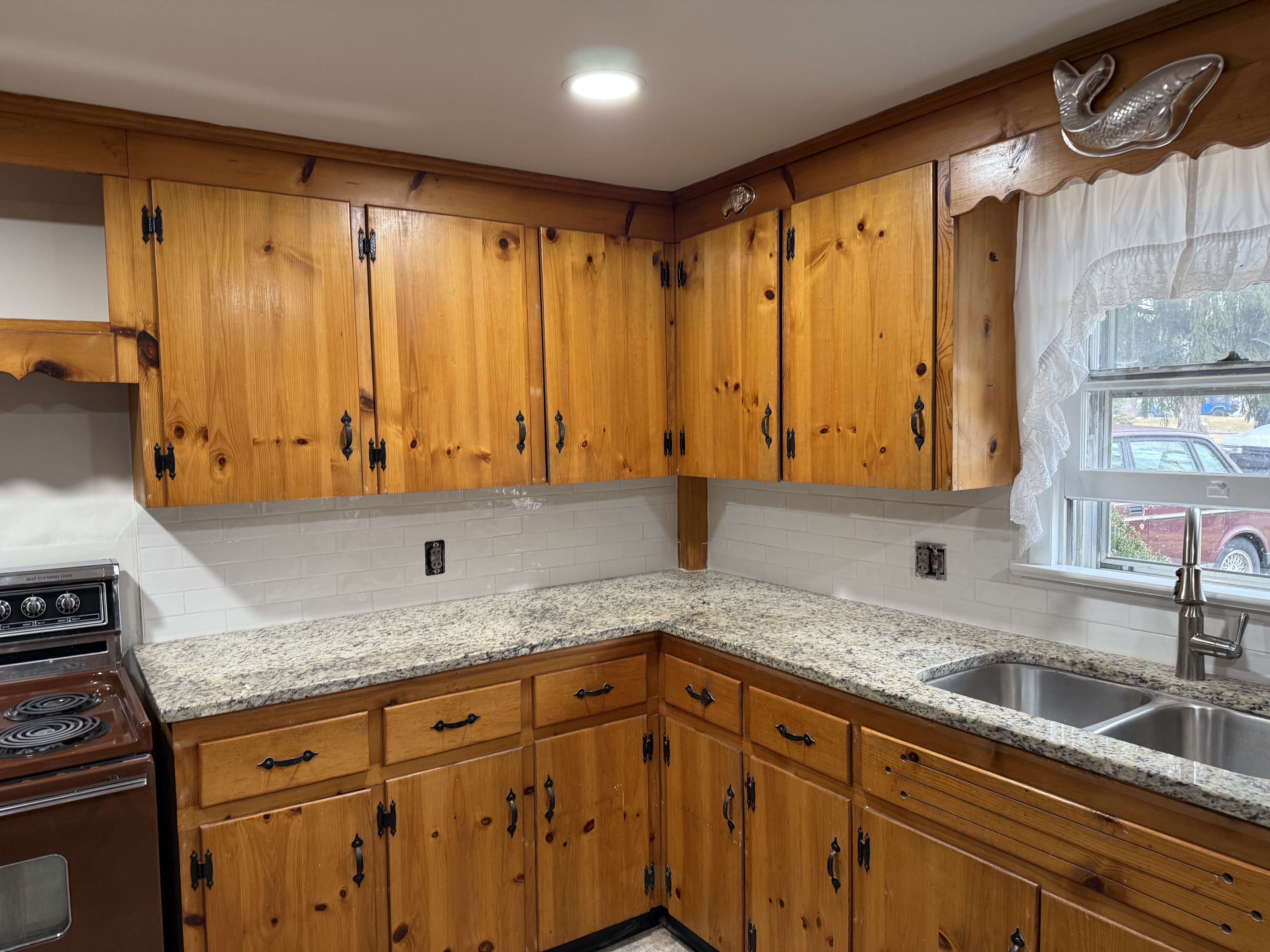 After kitchen remodel showing installed countertops, new sink, and finished backsplash