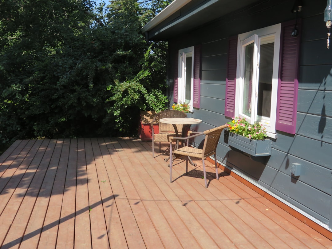 Finished wood deck beside the home with seating, planters, and a clean open layout