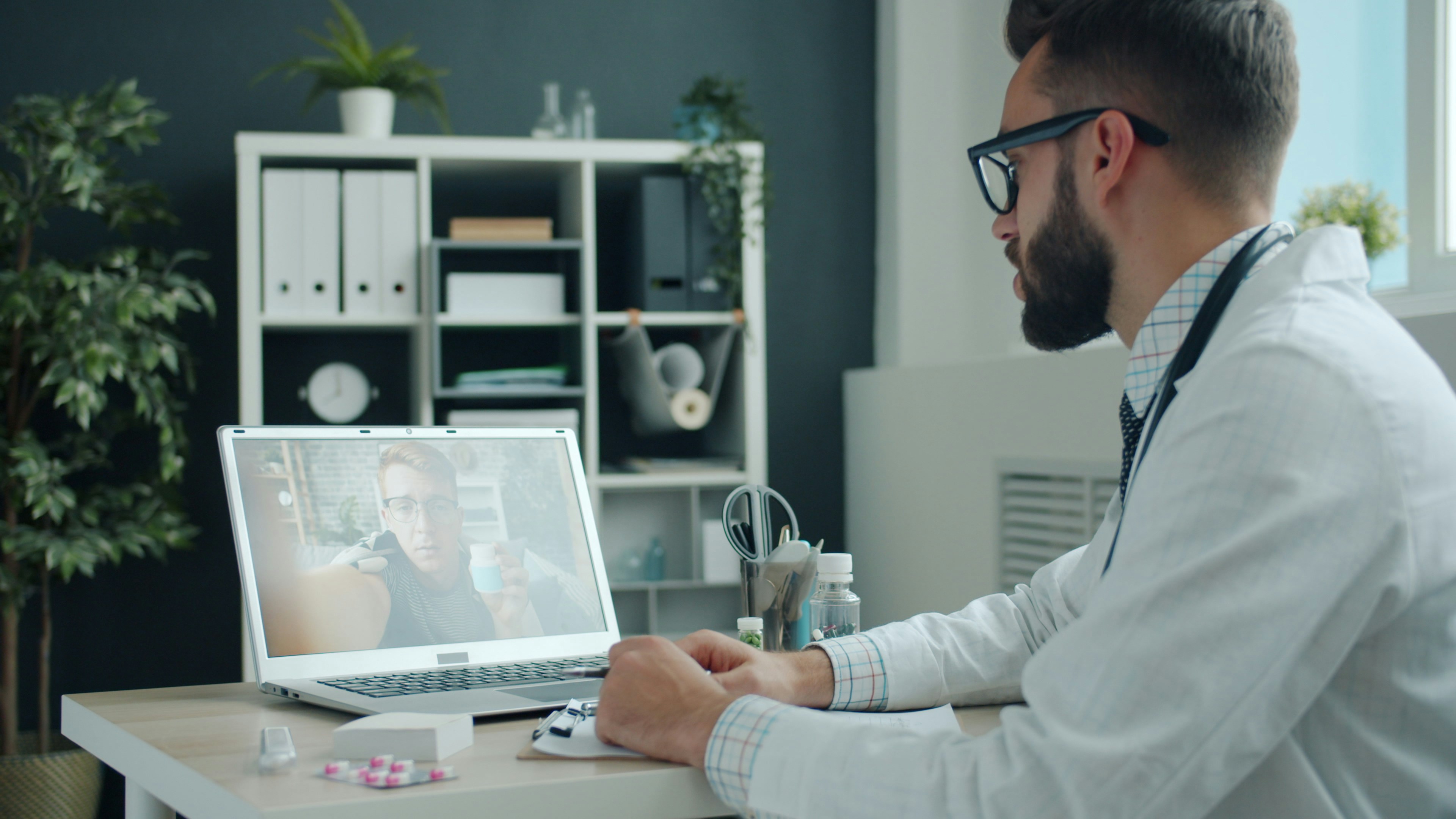 Woman sitting on sofa at home using a laptop for a medical consultation