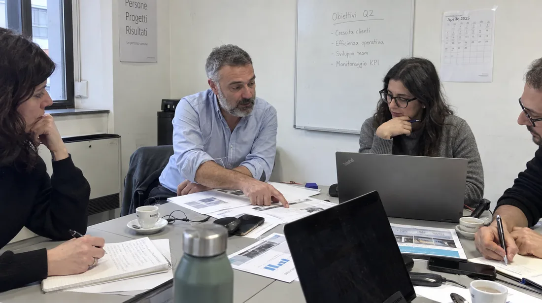 Consulenti attorno a un tavolo di riunione esaminano documenti stampati