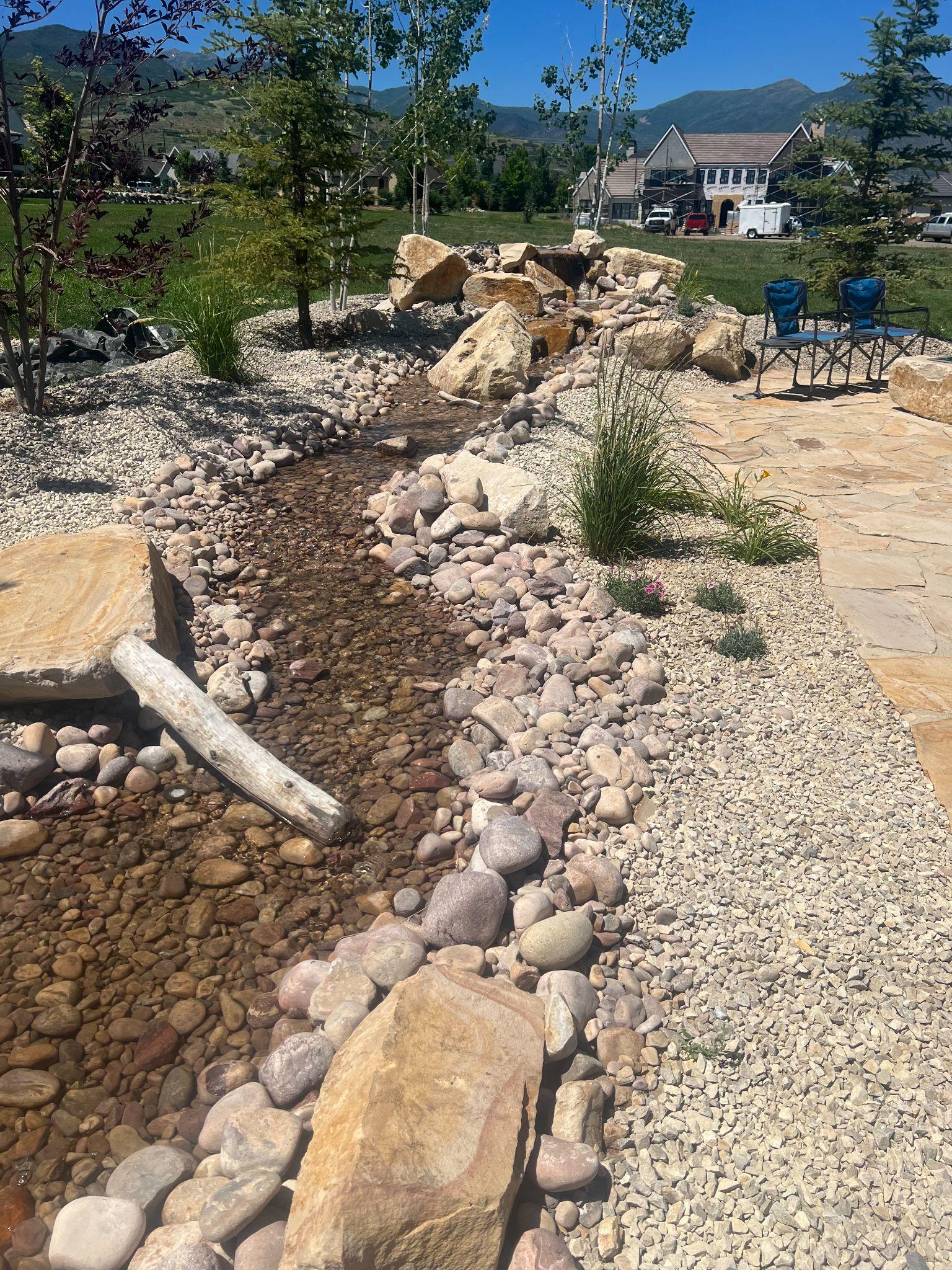 Dry creek bed with boulders and plants