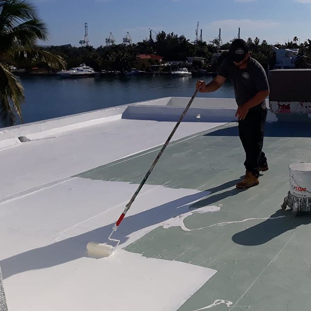 Crew applying HydroStop coating on a waterfront roof