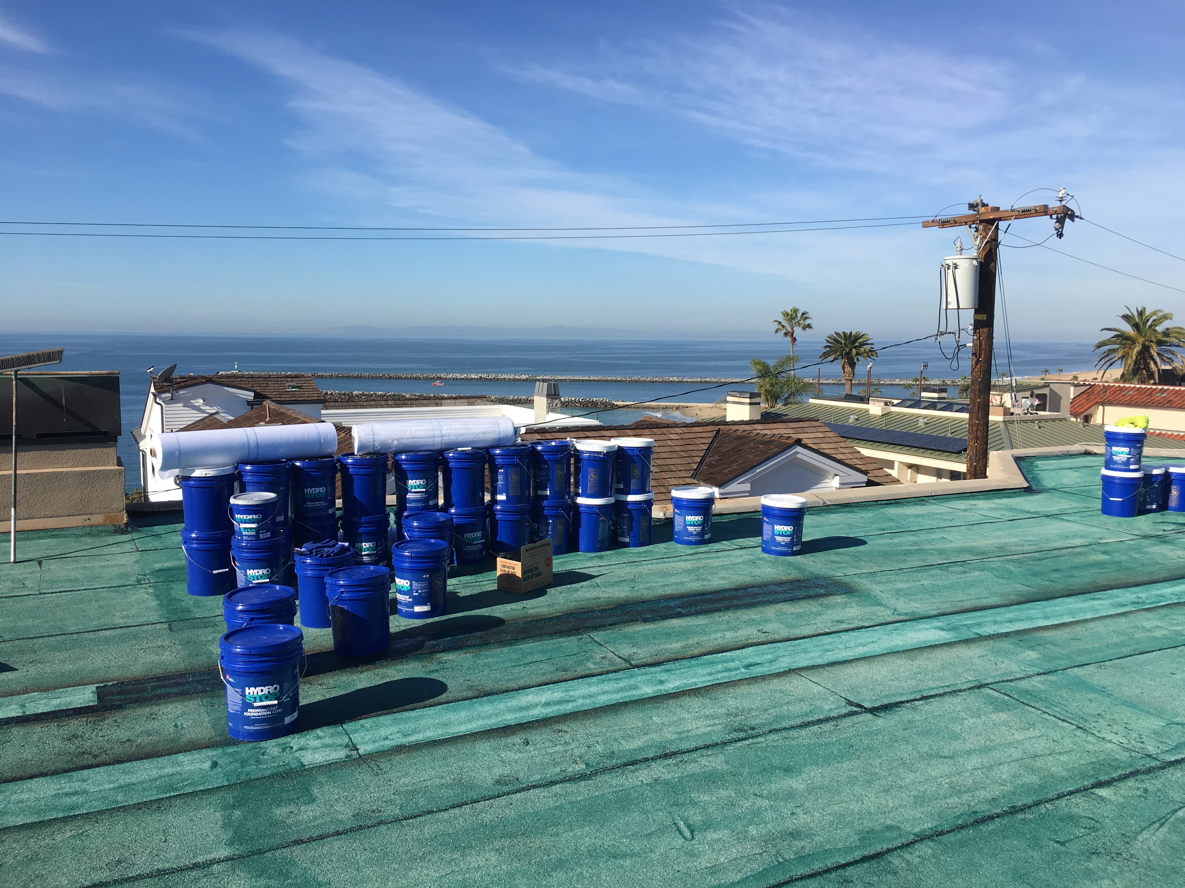 GAF product buckets on a coastal rooftop
