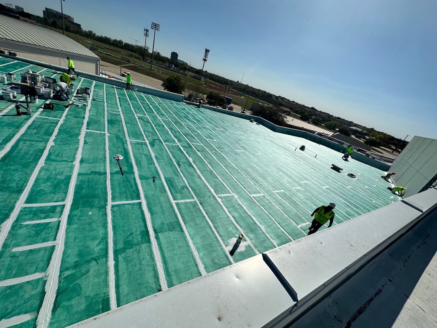 Crew applying coating in striped passes