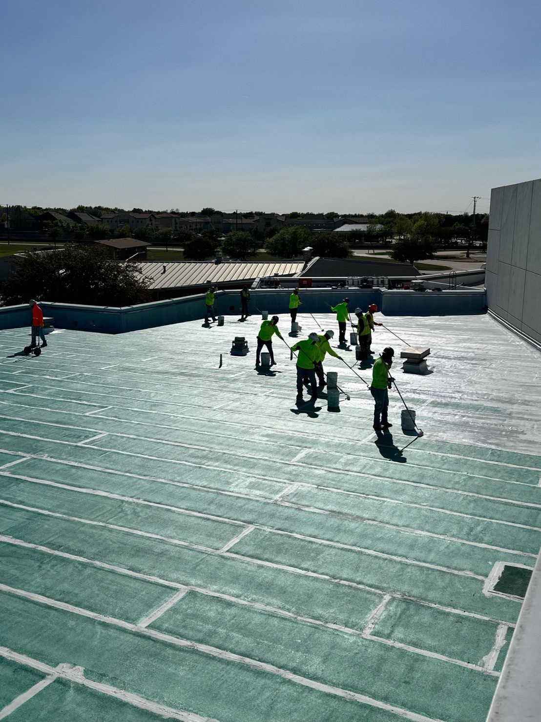 Crew in hi-vis working across a commercial roof