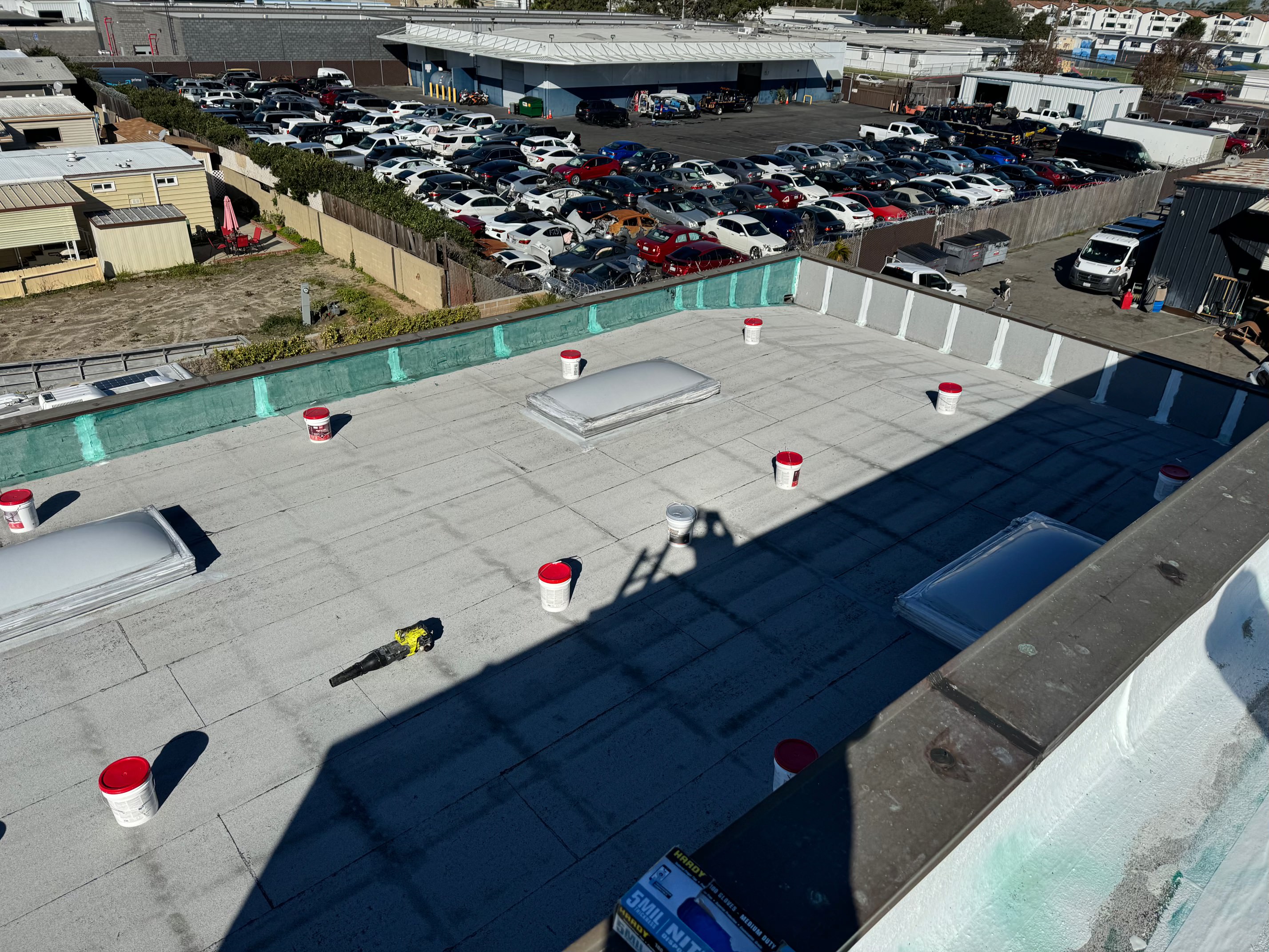 Aerial view of coating buckets staged on a commercial roof