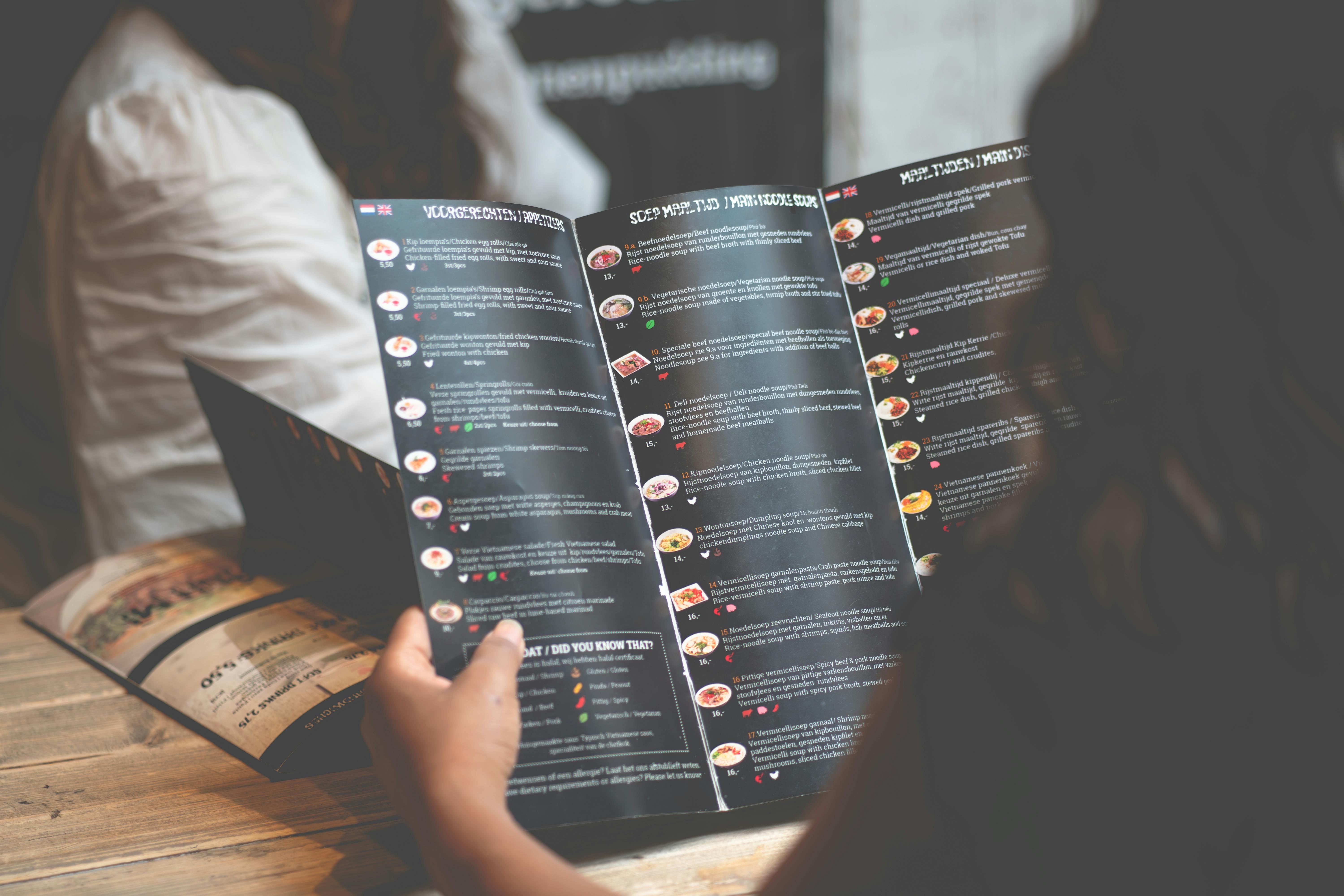 Guest reading menu at restaurant table