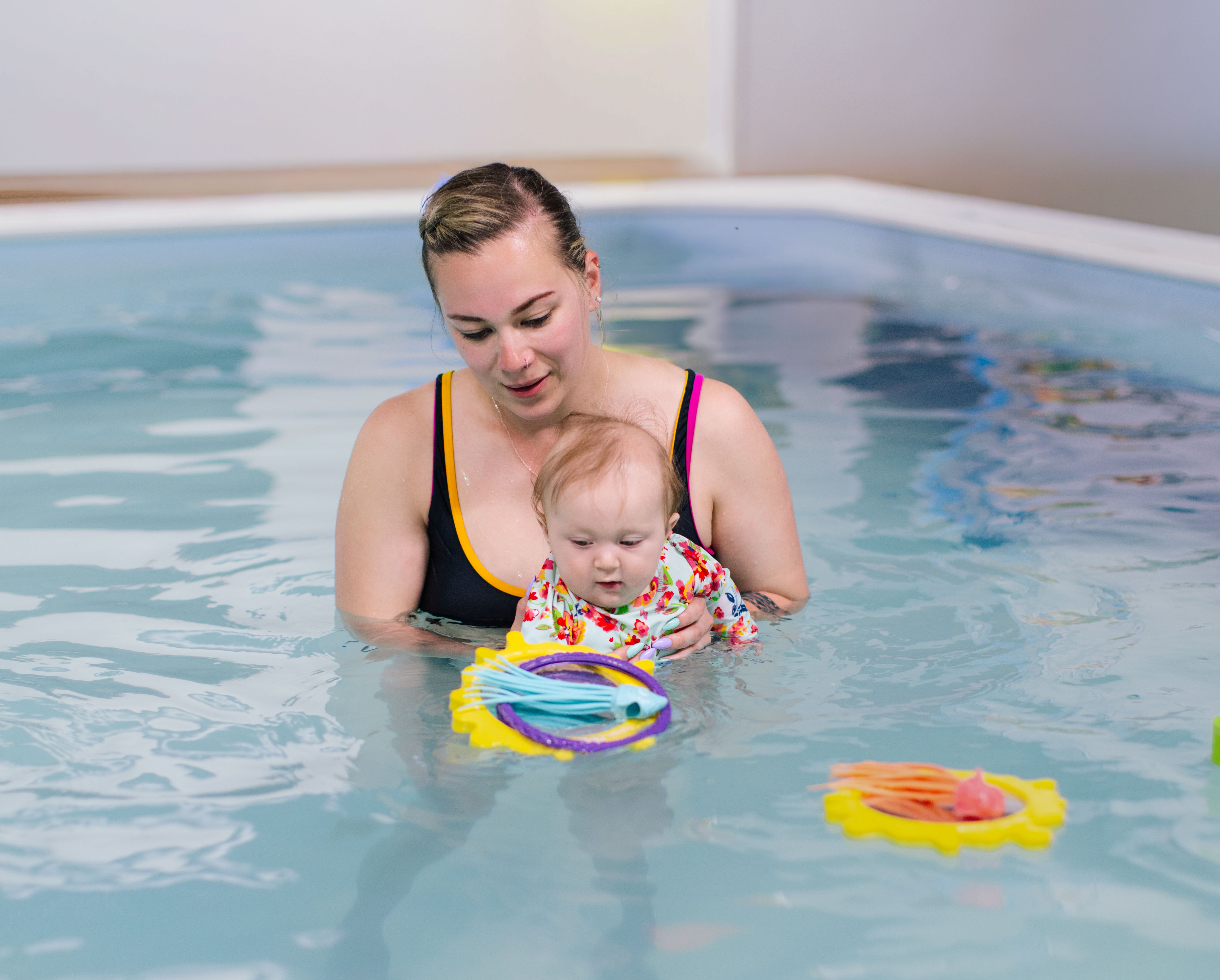 Instructor gently cradling an infant in the warm teaching pool